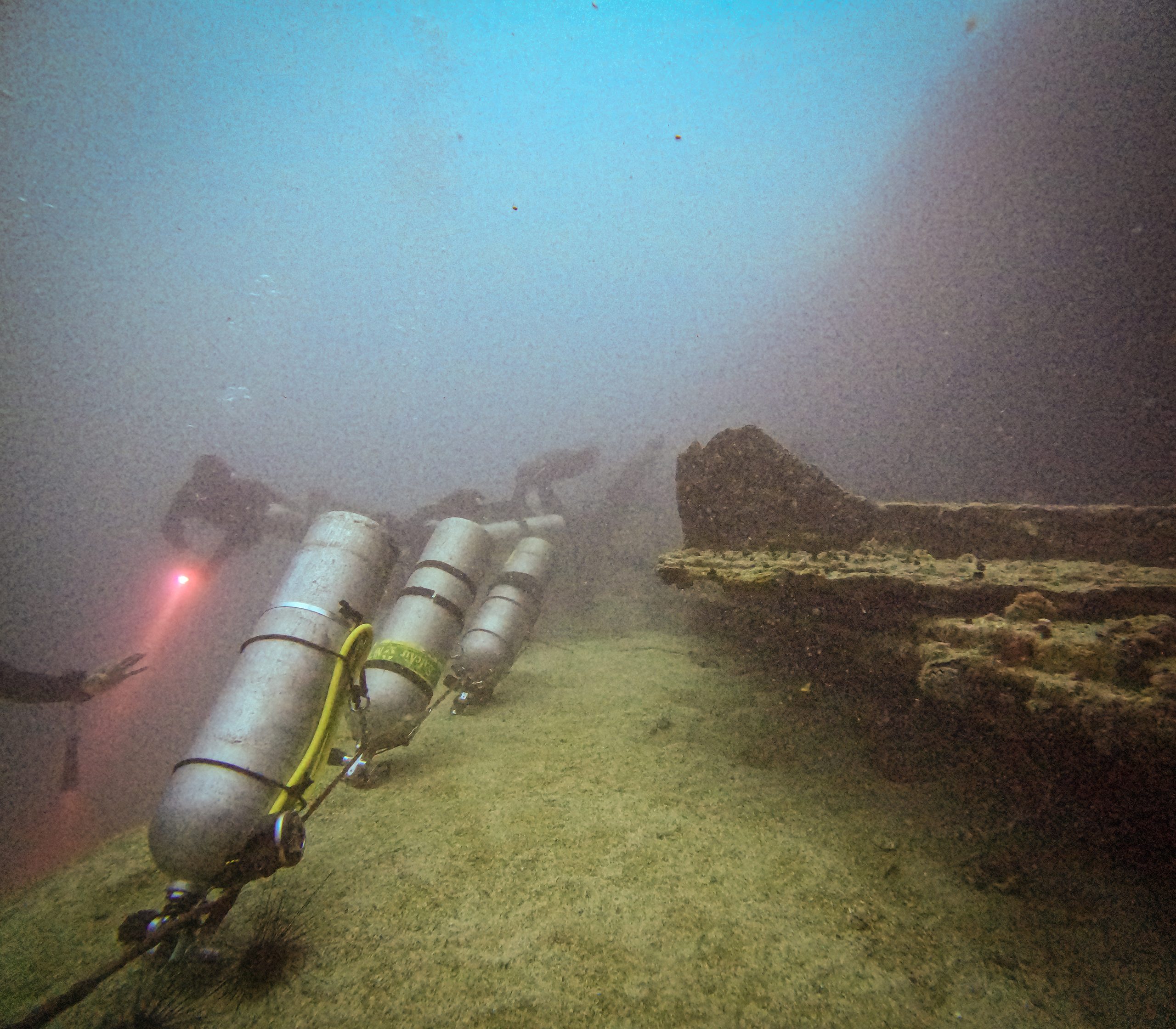 Sidemount cylinders staged on a wreck deck